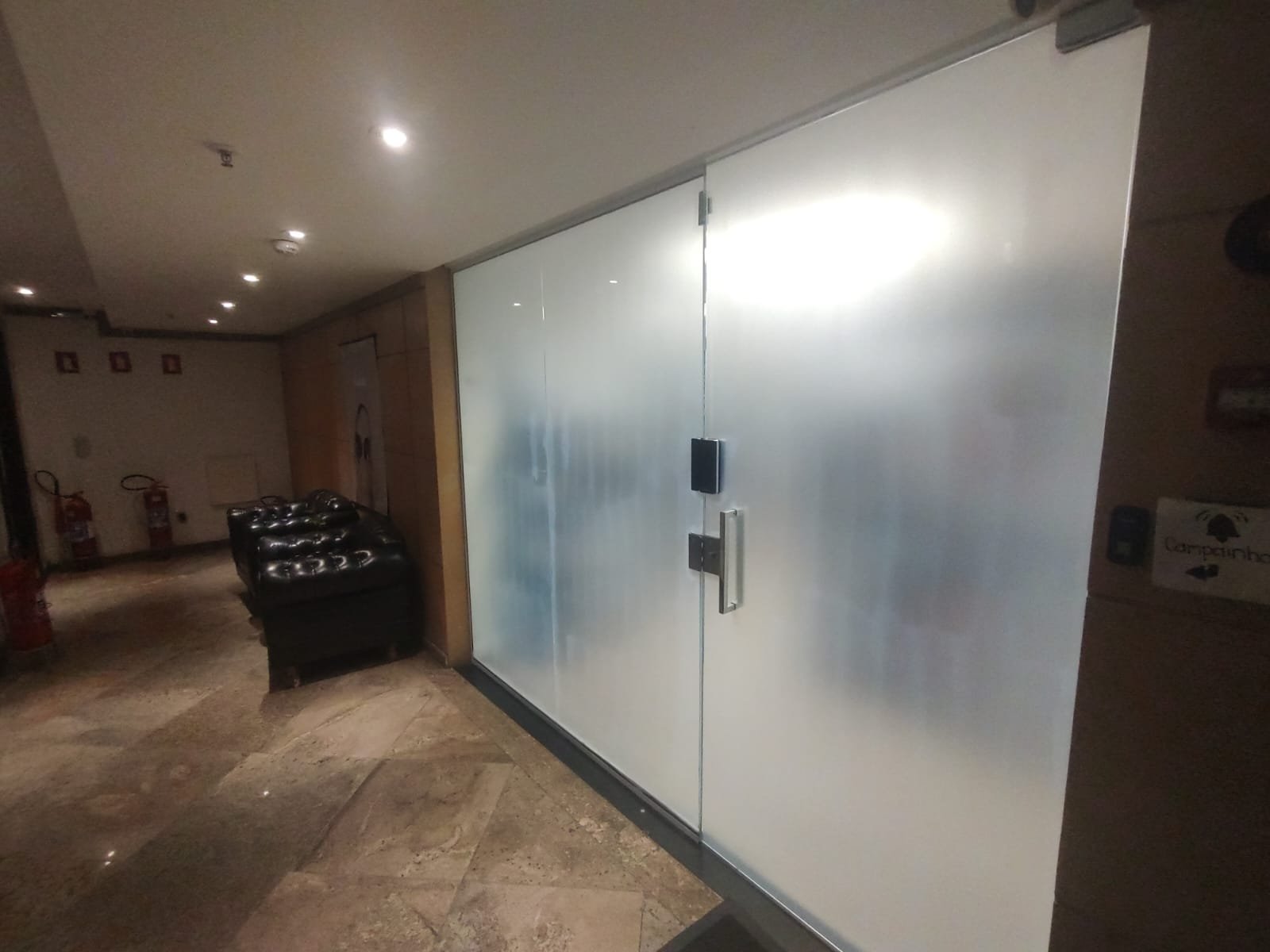 Película jateada aplicada em porta e divisória de vidro de escritório